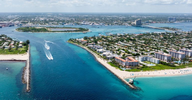 Aerial view of Palm Beach Inlet with turquoise waters, waterfront homes, and boating in The Palm Beaches.