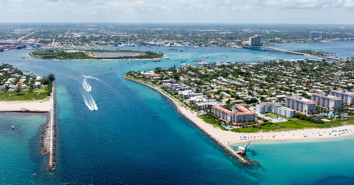 Aerial view of Palm Beach Inlet with turquoise waters, waterfront homes, and boating in The Palm Beaches.